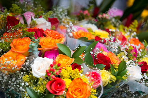 Preview: Colorful roses and baby's breath create a vibrant bouquet.
