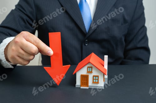 Preview: The businessman notes a fall in housing prices. Symbol of real estate market decline, mortgages