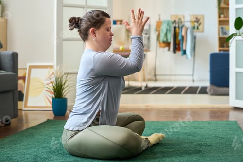 Preview: Young female in activewear keeping hands put together in front of her face