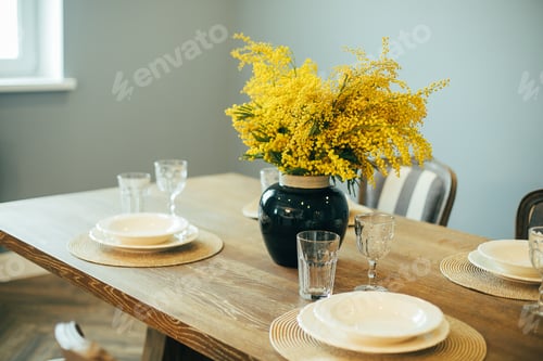 Preview: Festive Easter table setting. Branches of mimosa in vase. Home interior