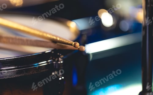 Preview: Close-up, snare drum and drumsticks on a dark background.