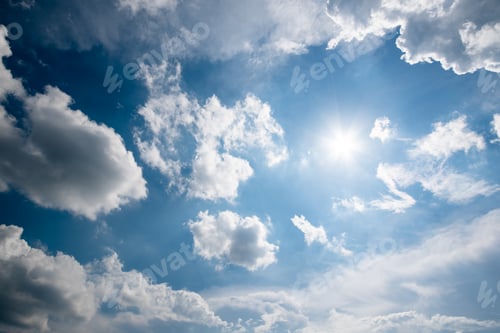 Vorschau: Blauer Himmel mit flauschigen Wolken und Sonne