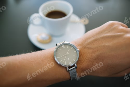 Preview: cropped image of classical wristlet with accurate mechanism on table in coffee shop