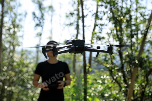 Preview: People remote control a flying drone in summer forest