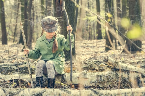 Preview: little girl in the woods sitting on a stump