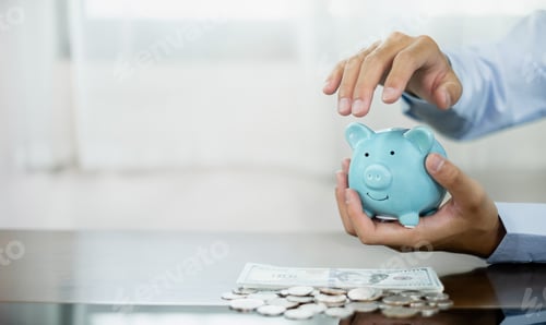 Preview: Hand protects a piggy bank save money with a pile of coins, steps into a successful growing business