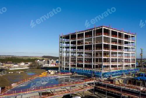 Preview: The framework of a tall building being constructed on a construction site with scaffold