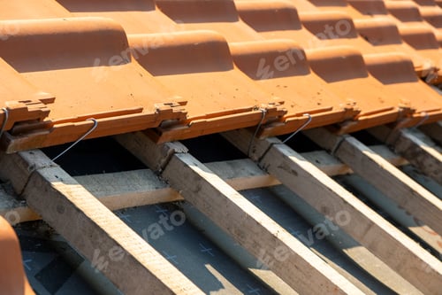 Preview: Overlapping rows of yellow ceramic roofing tiles mounted on wooden boards covering residential