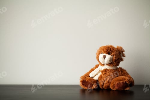 Preview: Brown teddy bear sit on wooden desk.