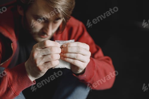Preview: Young addicted man with cocain packet sitting alone