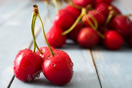 Preview: Fresh red cherries resting on rustic blue wooden table