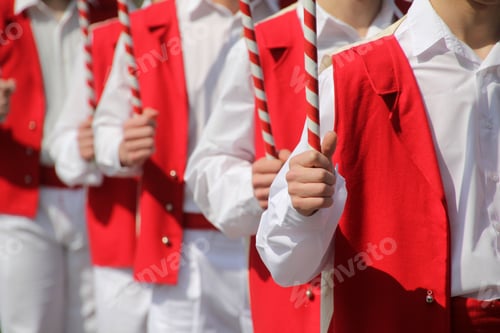 Preview: Ensemble Performers in Red Vests with Striped Poles