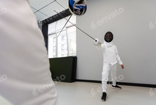 Preview: Children lunge on swords. A child in a class at a fencing school