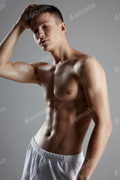 Preview: bodybuilder with a pumped-up torso in white shorts on a gray background