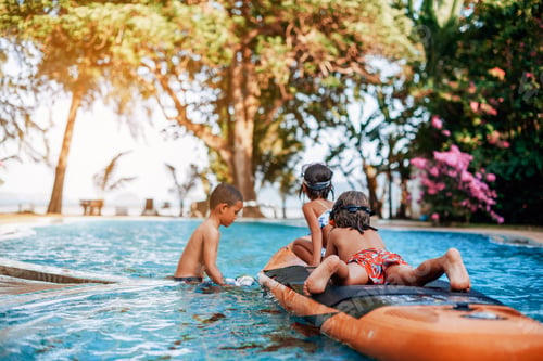Preview: Playful team of three children swimming in pool together