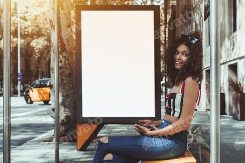 Preview: Curly woman on bus stop with empty billboard template behind