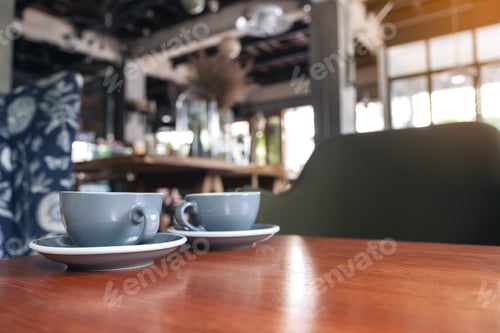 Preview: Closeup image of two blue cups of hot latte coffee on vintage wooden table in cafe