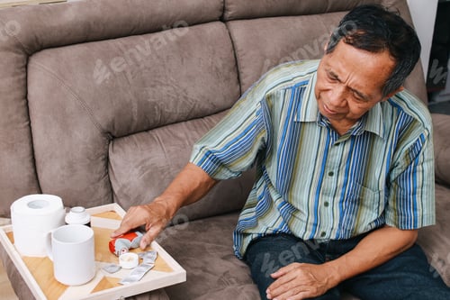 Preview: Man On Sofa Preparing His Medication At Home