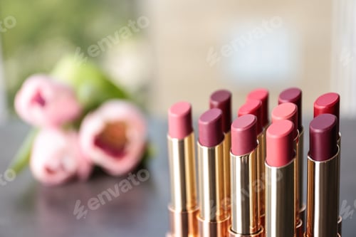 Preview: Set of bright lipsticks on blurred background. Space for text