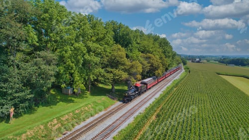 Preview: Drone View of an Antique Steam Engine, Approaching, Blowing Steam and Traveling Along
