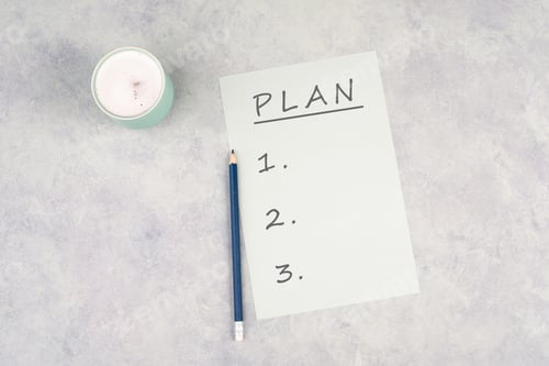 Preview: Empty paper with a pen on a textured background, the word plan is standing on the top of the page,