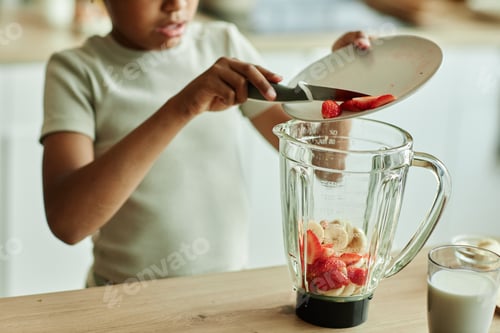 Preview: Girl Child Adding Strawberries to Blender at Kitchen