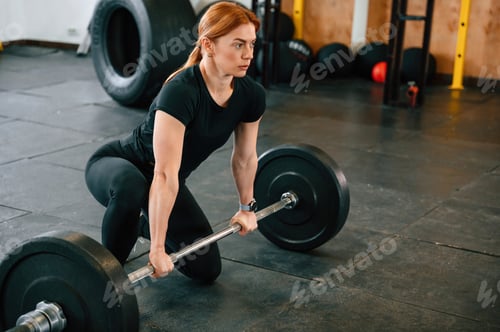 Preview: Ready to lift the barbell. Beautiful strong woman is in the gym