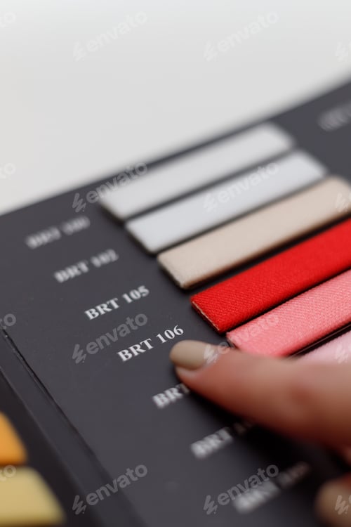 Preview: Female hand choosing right colour from catalogue, closeup