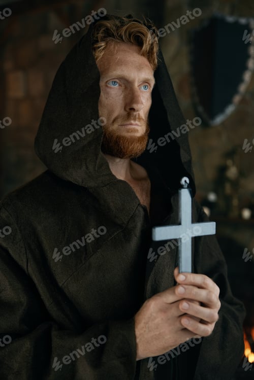 Preview: Medieval monk in robe praying holding silver cross in hand