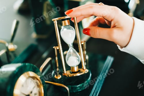 Preview: Vintage golden hourglass on the table, closeup.