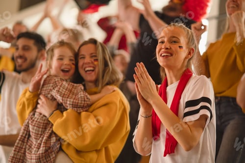 Preview: Excited football fans, mother with little daughter, supporting German national team in live soccer