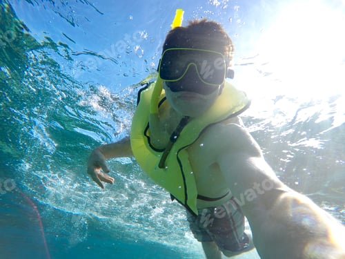 Preview: Man Snorkeling in the ocean with camera selfie vacation tropical getaway fun activity & water sport