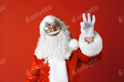 Preview: Authentic Santa Claus wearing funny glasses on color background