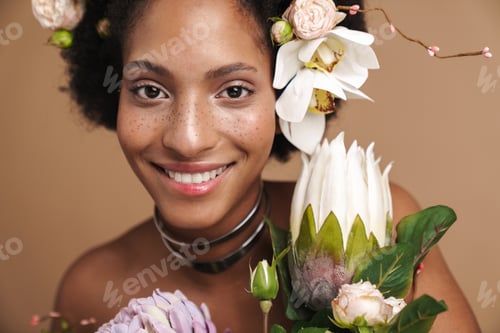 Preview: Portrait of young freckled african american woman posing with flowers