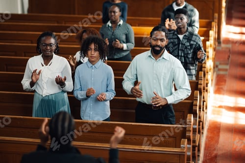 Preview: Congregation standing and praying together in church pew