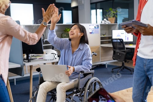 Preview: Business colleagues bond as an Asian woman in a wheelchair high-fives to boost teamwork