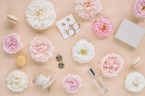 Preview: Accessories, perfume, garden roses's buds on beige background.