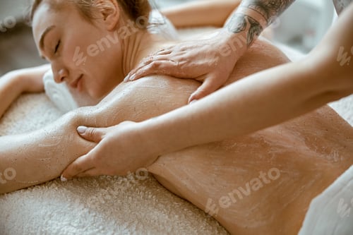 Preview: specialist is doing relaxing body massage for beautiful caucasian lady at minimalistic spa salon