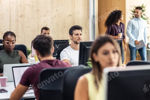 Preview: Multiethnic businesspeople working with computers in a coworking place.