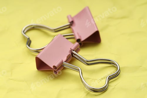 Preview: Beautiful binder clips on crumpled yellow paper, closeup
