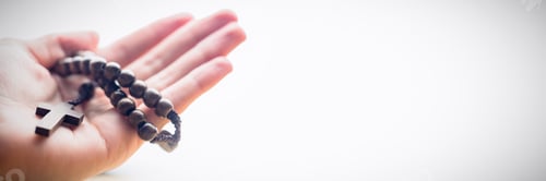 Preview: Hand holding rosary beads