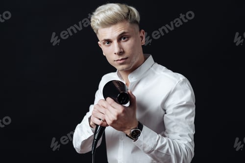 Preview: Smiling male hairdresser holding a blow dryer