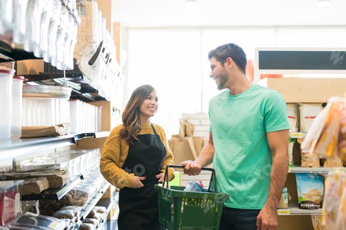 Preview: Smiling Female Worker With Buyer In Supermarket