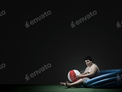 Preview: Boy in paddling pool with beach ball