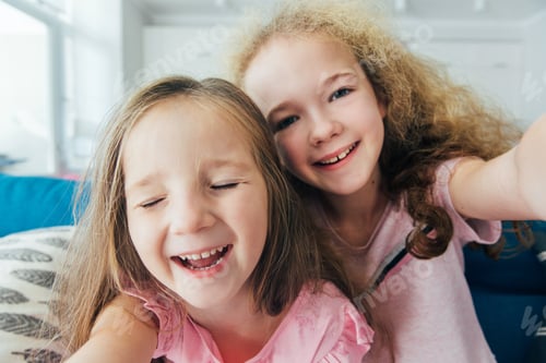 Preview: Self portrait of crazy, foolish sisters, laughing, together making selfie on mobile phone or camera