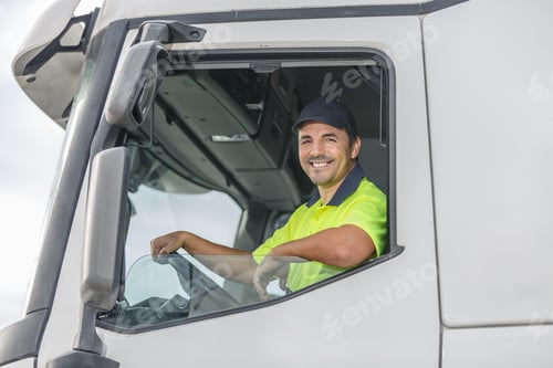 Preview: Smiling male driver looking through window of truck
