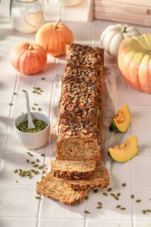 Preview: Fresh pumpkin bread with orange squashes and seeds.