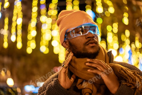 Preview: African man using smart glasses in the city at night