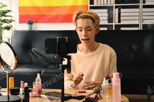 Preview: Young queer man beauty make up artist or vlogger recording makeup tutorial in home.