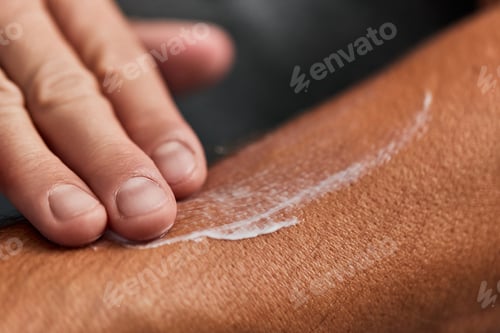 Preview: A male putting a lotion on his skin, taking care of his skin, rubbing with his fingers.